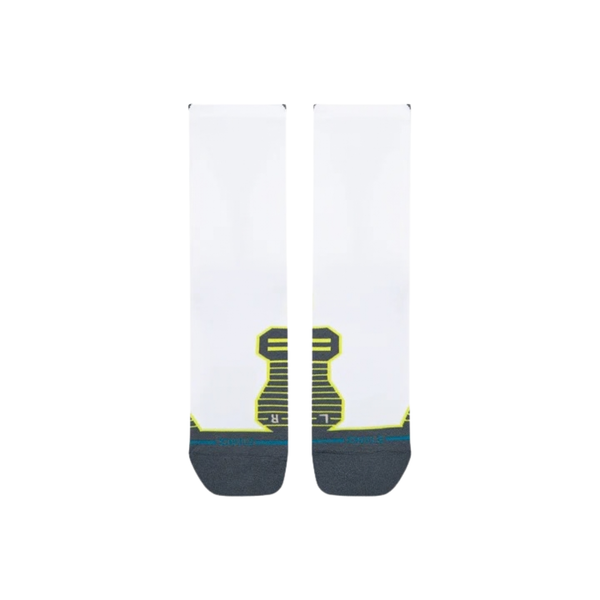Et par Stance Funnel Light Crew unisex-sokker i hvidt ligger fladt side om side på en hvid baggrund. Disse sokker har mørkegrå tåpartier, gule og grønne detaljer samt et karakteristisk stribet mønster ved fodbuen, hvilket fremhæver deres stilfulde udseende og lover komfortable sokker til hverdagsbrug.