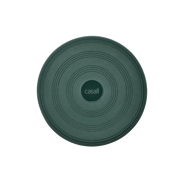 En mørk blågrøn, rund Casall Balance Cushion med koncentriske cirkler og et centralt logo, ideel til coretræning eller rehabilitering, afbildet på en hvid baggrund.