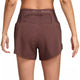 En person ses bagfra iført Nike Dri-FIT Trail Mid-Rise 4" Brief-Lined Running Shorts til kvinder i Red Sepia/Black med en lille lynlåslomme nær linningen. Baggrunden er hvid.