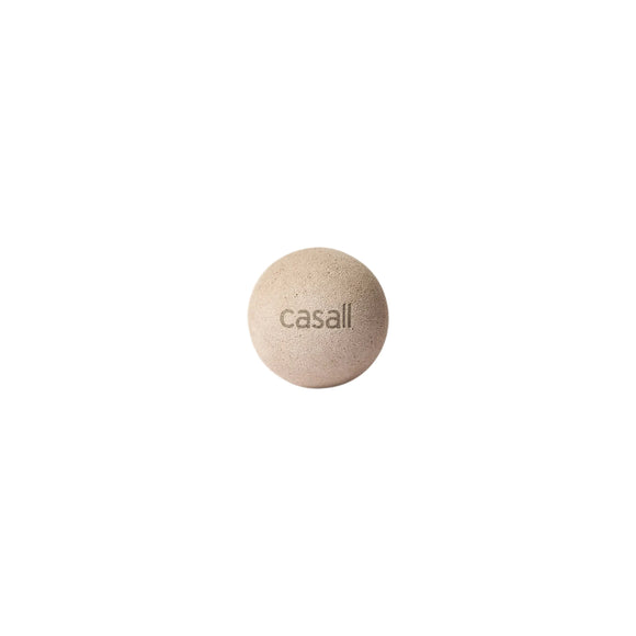 En beige, rund Casall Pressure Point Ball i lys kashmir med mærkets logo, designet til massage af triggerpunkter og lindring af muskelspændinger, er vist centreret på en almindelig hvid baggrund.