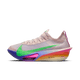 Nike Alphafly Next% 3 "Eliud Kipchoge" til mænd i Silt Red/Green Shock-Bright Ceramic har en lyserød overdel, grøn swoosh, regnbuesål og teksten "No Human is Limited" på en almindelig hvid baggrund.