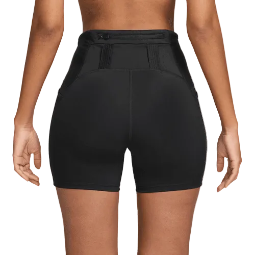 En kvinde ses bagfra iført Nike Dri-FIT High-Waisted 4" Tight Running Shorts i sort/sort med synlige sømme og strukturerede paneler, mens armene hviler i siden.