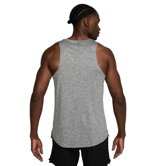 En person med flettet hår ses bagfra iført en Nike Stride Running Tank til mænd i Smoke Grey/Htr/Reflective Silv og sorte shorts på en almindelig hvid baggrund.