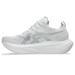 Asics Megablast (Unisex) i White/Piedmont Grey er en atletisk løbesko med en tyk sål, minimalistisk design, diskrete sidelinjer, responsiv støddæmpning, snørelukning og en trækflig i hælen.