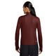 En person set bagfra iført en mørk rødbrun Nike Dri-FIT 1/2-Zip Trail Running Top, Dame, i farvekombinationen Mystic Dates/Mystic Dates/Summit White, med lange ærmer, tommelfingerhuller og et logo nederst på kanten.
