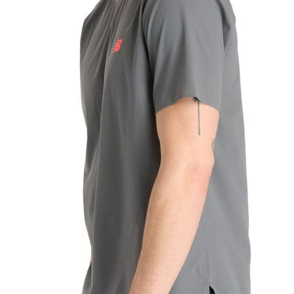 En mand ses fra siden iført en grå New Balance Race Day Ulitra Light T-shirt (Herre, Urgent Red) med et lille rødt logo på brystet; man kan se hans højre arm og en tatovering på indersiden af overarmen.