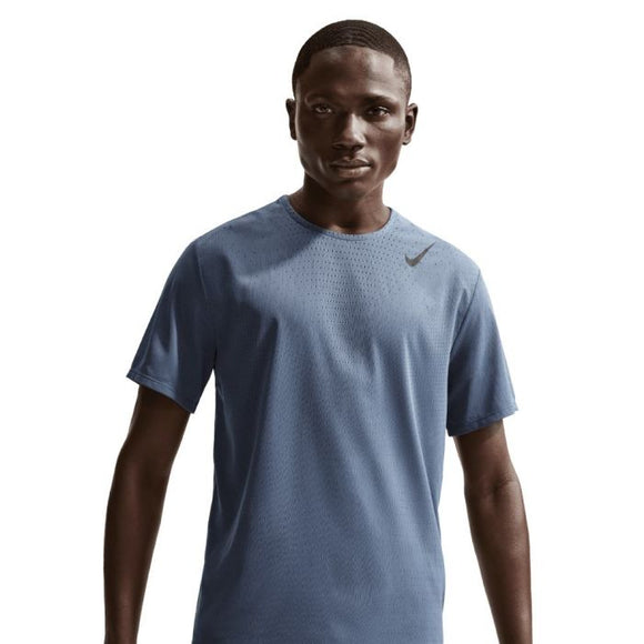 En herre står fremadvendt iført Nike Nk Dfadv Aroswft Ss Top i Diffused Blue/Black med et lille sort Nike-logo på venstre bryst. Baggrunden er helt hvid.