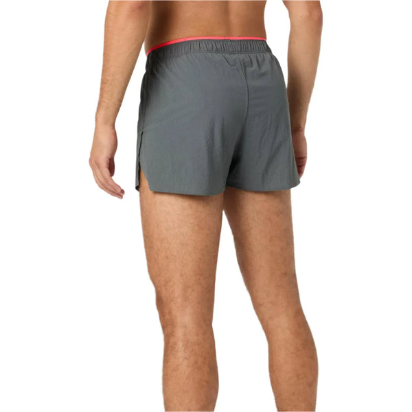 En person ses bagfra iført New Balance RC Ultra Light Split Short 3", Herre, i Urgent Red med sidesplit og en rød linning, der afslører deres barmfagre lænd og ben. Inspireret af det klassiske RC Split Short-design.