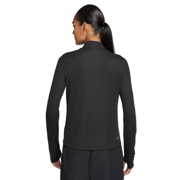 En kvinde med mørkt hår i en lav hestehale ses bagfra iført Nike ACG Half Zip Running Top til kvinder i Black/Black/Summit White på en almindelig hvid baggrund.