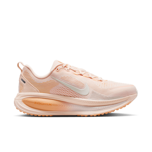Nike Vomero 18 dame i Guava Ice/Sail-Orange Chalk har en overdel i ferskenfarvet mesh, hvid swoosh, ZoomX-skumsål og orange kridt ydersål, vist på en almindelig hvid baggrund.
