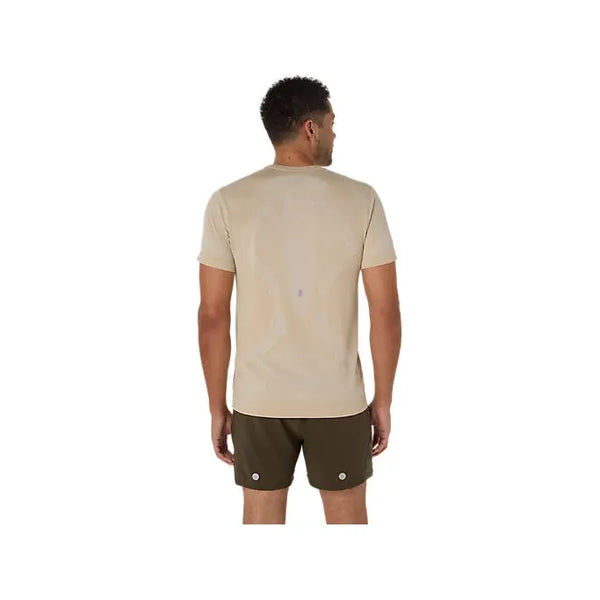En mand står med ryggen til kameraet iført en Asics Road Seamless Ss Top, Herre, Cream og olivengrønne shorts på en hvid baggrund.