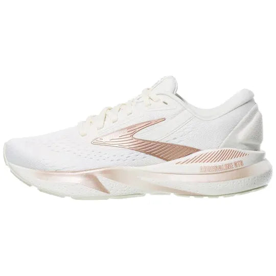 Brooks Adrenaline GTS 24 Dame i Coconut/Rose Gold/White er en stabilitetssko med ekstra støtte, lavt design, struktureret sål og en lyserød metallisk accent langs siden og mellemsålen.