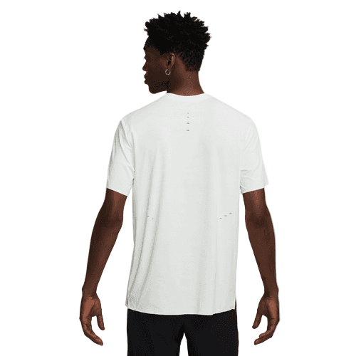 En person kigger væk fra kameraet iført Nike Dri-FIT ADV Short-Sleeve Running Top, Herre, Summit White/Blkref og sorte bukser. Den ensfarvede hvide baggrund fremhæver den atletiske herrestil.