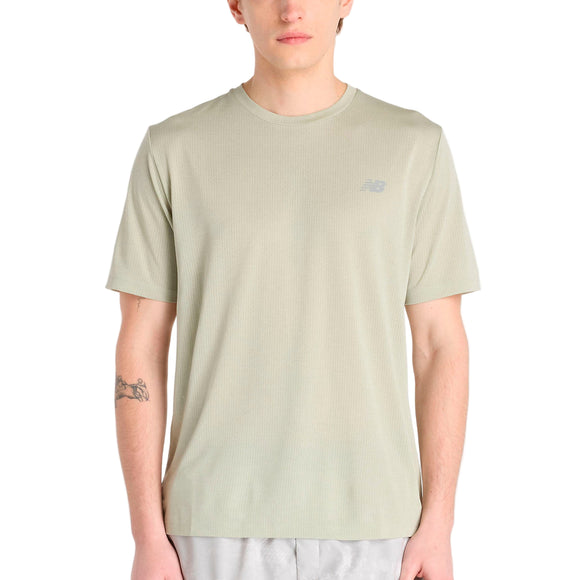 En person iført en New Balance Athletics T-shirt til mænd i Garter Snake Heather og lysegrå shorts, vendt fremad med armene ned langs siden og en tatovering på venstre underarm.