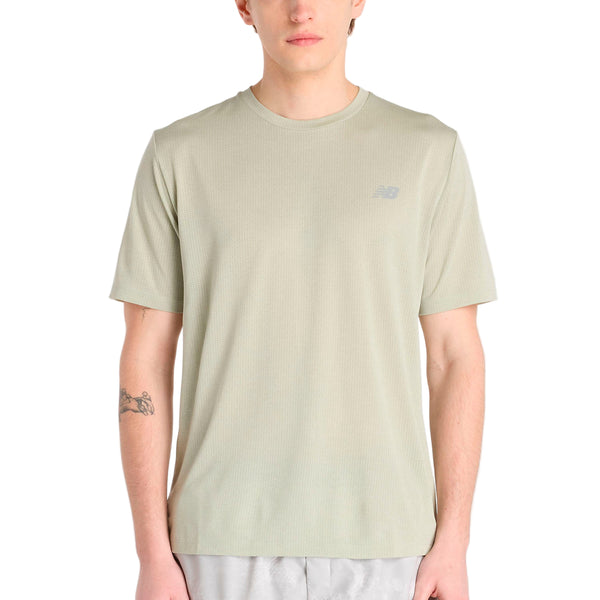 En person iført en New Balance Athletics T-shirt til mænd i Garter Snake Heather og lysegrå shorts, vendt fremad med armene ned langs siden og en tatovering på venstre underarm.