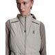 En person bærer On Weather Vest, Dame, Desert/Eclipse - en let beige vest med hætte og brystlogo - over en taupefarvet langærmet skjorte og kigger lidt til siden mod en hvid baggrund.