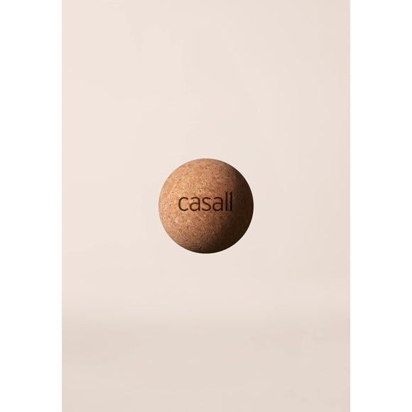 En Casall Pressure Point Ball lavet af naturkork er centreret mod en almindelig, lys beige baggrund med mærkenavnet "casall" trykt på den.
