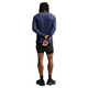 En person står med ryggen til og har en Nike Dri-FIT ADV langærmet løbetrøje til mænd i farven Midnight Navy/Reflective Silver på, kombineret med sorte shorts og sneakers. Armene er bag ryggen, og hænderne er foldet. Det avancerede Dri-FIT ADV-materiale i Nike-trøjen sikrer komfort og høj ydeevne på den ensfarvede hvide baggrund.