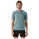 En mand står og kigger fremad iført en Patagonia M's Ridge Flow Shirt, Herre, Wetland Blue - en åndbar løbetrøje - og sorte shorts mod en almindelig hvid baggrund.