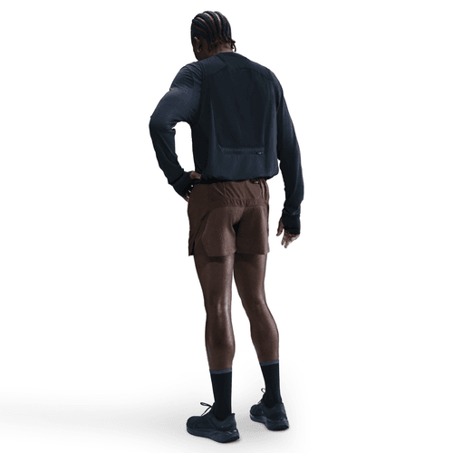 En person står med ryggen til og er iført en sort langærmet sportstrøje, Nike 5" Dri-FIT ADV Brief-Lined Running Shorts til mænd i Baroque Brown/Black/Blkref, sorte sokker og sorte sportssko. Baggrunden er helt hvid.