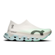 ON Cloudmonster 3 Hyper LS (Unisex, Flurry/Verdite) er en hvid slip-on-sportssko med en gennemsigtig overdel, en lyseblå mellemsål, grønne detaljer og en tyk, geometrisk sål med Helion HF-hyperskum, der sikrer komfort, samt minimalt mærke på siden.