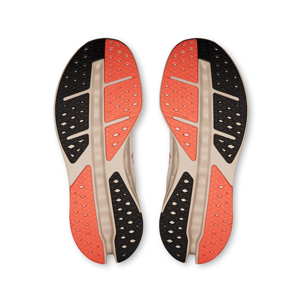 On Cloudsurfer Max Dame Ivory/Salmon-sålerne vises nedefra med orange, sort og beige teksturerede gummigrebzoner med segmenterede riller, der giver et godt greb, og som forstærkes af CloudTec Phase-teknologien.