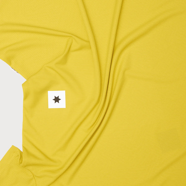 Saysky Reactive Flow T-Shirt, Herre, Yellow Aop har gult hurtigtørrende stof med en subtil gitterstruktur og synlige folder samt en lille hvid firkant med en sort stjerne. Fremstillet af åndbart materiale for komfort.