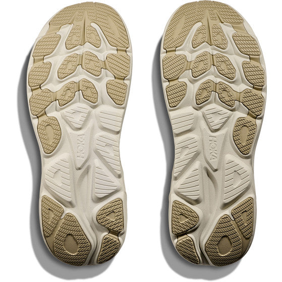 Hoka Clifton 10 herre løbesko i Fern/Truffle Salt har to såler med geometrisk mønster, der giver greb og stabilitet. Maksimal dæmpning øger komforten, hvilket gør dem perfekte til daglige løbeture. Hoka branding vises i midten af hver sål.