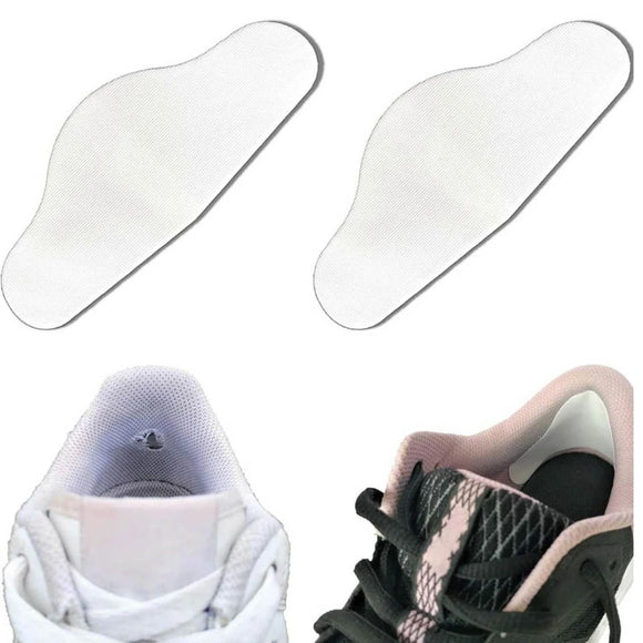 To Trainer Armour Heel Hole Preventers i hvid vises over et par sneakers - den ene hvid, den anden sort med pink detaljer. Disse unisex-beskyttere passer ind i skoene og hjælper med at forhindre hælhuller og rynker.