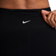 En hånd, der åbner en lomme med lynlås bagpå et par sorte Nike-løbetights med høj talje og fuld længde.