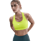 En kvinde med tilbagestrøget blondt hår bærer Nike Swoosh Medium Sports Bra til kvinder i Cyber/White og mørke leggings, mens hun står med hænderne bag ryggen og kigger lidt til siden mod en hvid baggrund.