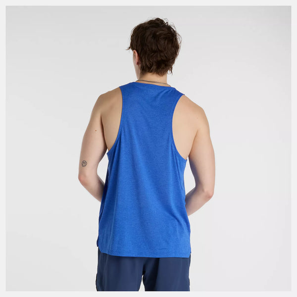 En person med kort brunt hår står med ryggen til kameraet iført en blå New Balance Athletics Tank, Herre i Blue Gemstone Heather og mørke shorts - ideelt til et træningssæt herre - mod en almindelig hvid baggrund.