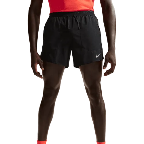 En person i rød skjorte, Nike Stride 5" Brief-Lined Running Shorts (Herre, Black/Reflective Silv) og røde sokker står på en almindelig lys baggrund. Billedet er beskåret fra brystet og ned.