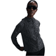En person iført store mørke solbriller og en sort Nike Dri-FIT løbejakke til kvinder i Black/Anthracite/Reflective Silver med hætte står på en hvid baggrund og poserer afslappet med den ene hånd på hoften.