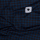 Nærbillede af blåt og sort houndstooth-stof fra Saysky W Houndstooth Combat Singlet (Dame, Blue Aop) med et hvidt rektangulært mærke med en sort stjerne i øverste højre hjørne.
