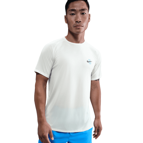 En mand står foran en ensfarvet baggrund iført en hvid Nike Stride Running Short-Sleeve Top, Herre, Sail med et lille logo på brystet og lyseblå shorts og ser direkte ind i kameraet med et neutralt udtryk.