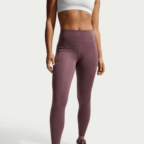En person iført en hvid sports-bh og Nike Nk Df Swift Hr 7/8 Tight, Dame, Tattoo/Reflective Silv står mod en hvid baggrund. Kun torso og ben er synlige.