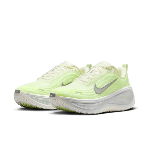 Et par Nike Vomero Plus dame løbesko i Sail/Metallic Silver-Barely Volt med hvide såler og grå swooshes, ReactX-mellemsål, vist i en trekvart vinkel mod en almindelig hvid baggrund.