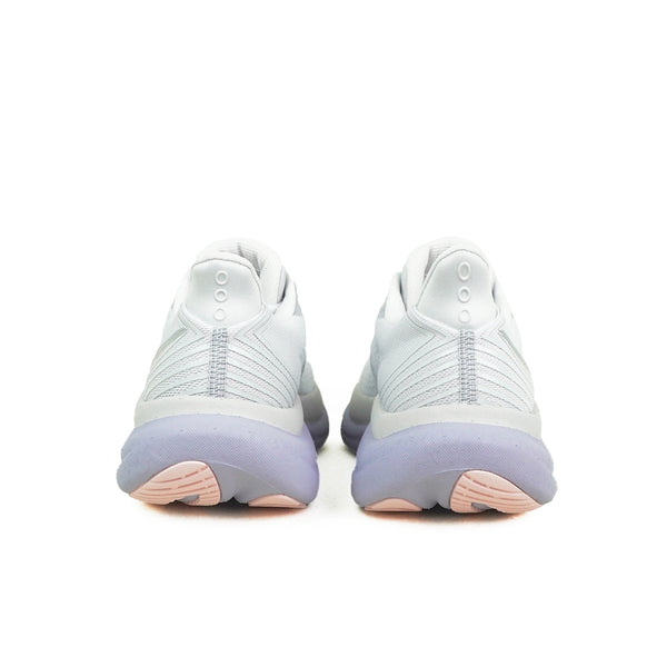 Et par hvide Saucony Triumph 23, Dame, Aster løbesko set bagfra med lyslilla mellemsåler, lyserøde ydersåler, et struktureret design og to ventilationshuller nær toppen af hver hæl.