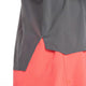 Nærbillede af en person iført New Balance Race Day Ultra Light Singlet til mænd i Urgent Red; kun den nederste del af singletten og de øverste shorts er synlige mod en almindelig hvid baggrund.