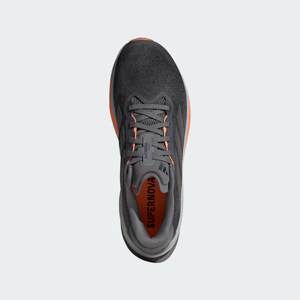 Et topbillede af Adidas Supernova Prima 2 herre løbesko i Grefou/Ironmt/Luor, en mørkegrå herreløbesko med orange detaljer, grå snørebånd og SUPERNOVA trykt i orange på indersålen.