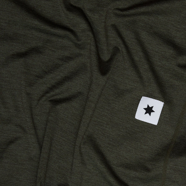 Saysky W Pace 1/2 Zip Long Sleeve til kvinder i grøn har en hvid firkantet patch med en sort stjerne og viser synlige folder og en blød tekstur.