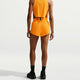 En mand i et gult outfit fuldender sit look med Nike AeroSwift Mid-Rise 3In Running Shorts i Laser Orange/Black/White, der fremhæver en elegant og atletisk stil.