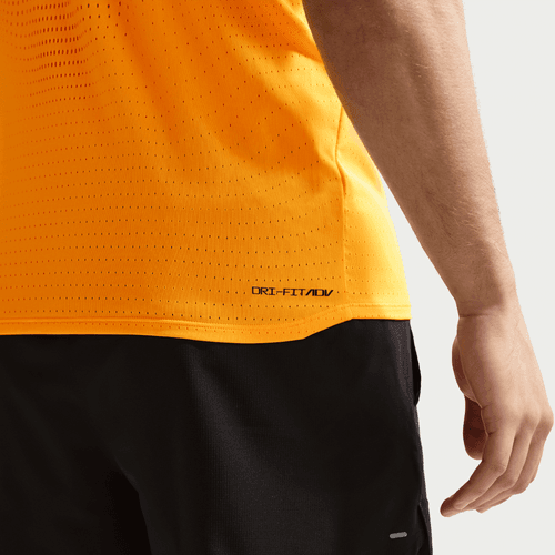 En mand ses bagfra iført en Nike AeroSwift Running Singlet, Herre, i Laser Orange/Black lavet af fugttransporterende stof og sorte shorts med "DRI-FIT ADV" trykt nær kanten. Hans arm er delvist synlig.