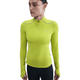 En kvinde i en tætsiddende Nike Therma-FIT ADV 1/2-Zip Reflective Running Top i Cyber/Reflective Silv sammen med sorte leggings står på en almindelig hvid baggrund.