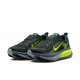 Et par Nike Vomero 18 Herre løbesko i Seaweed/Volt-Cannon-Sanded Purple, med lyse gulgrønne detaljer og et tykt lilla-grønt ZoomX-mellemsål, vises mod en almindelig hvid baggrund.