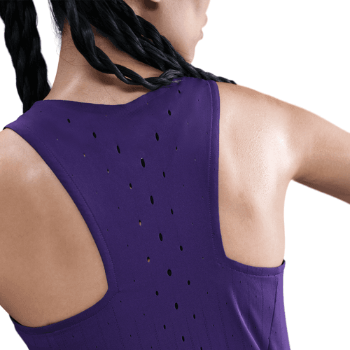 En kvinde med flettet hår viser Nike AeroSwift Running Singlet til kvinder i Court Purple/White med Dri-FIT ADV og ventilationshuller på ryggen; hendes ryg og overarm ses mod en hvid baggrund.