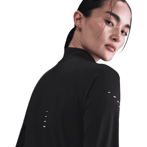 En kvinde med mørkt hår, der er bundet tilbage, ses bagfra iført det sorte Nike Dri-FIT Full-Zip Running Mid Layer for dames med reflekterende detaljer - ideel løbetøj dame til aftenløb.