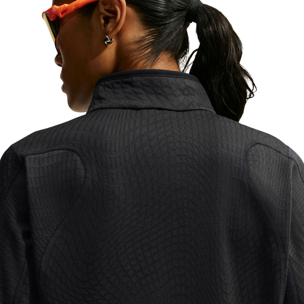 Nærbillede set bagfra af en sort Nike Therma-FIT 1/2-Zip Top med strukturmønster og sømdetaljer på skuldrene.