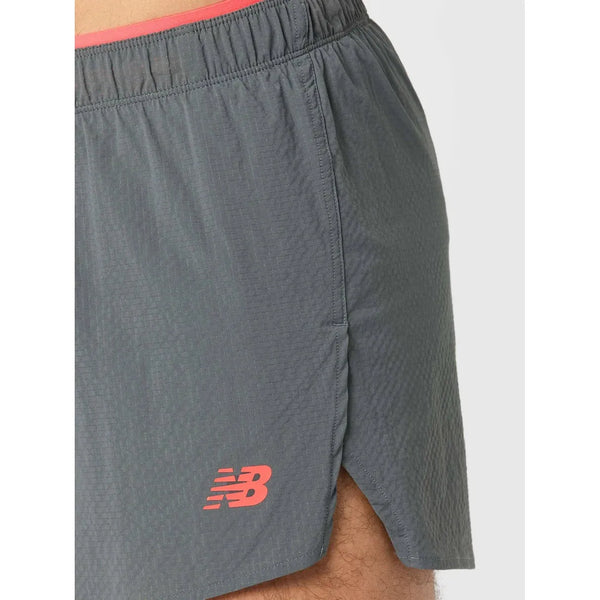 Nærbillede af RC Ultra Light Split Short 3" til mænd fra New Balance i Urgent Red med rødt logo forneden, slidser i siderne og NB DRY-teknologi til fugtstyring.